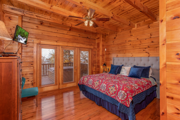 Master bedroom with wall mounted television at The Original American Dream, a 2 bedroom cabin rental located in Gatlinburg