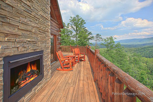 Deck with fireplace and rocking chairs at Majestic Views, a 3 bedroom cabin rental located in Pigeon Forge