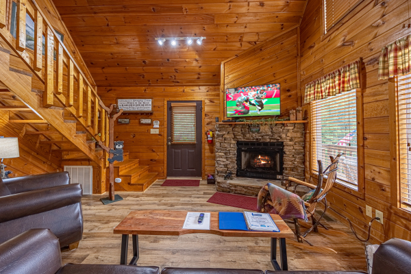 Living room with stairs at Cabin On The Hill, a 1 bedroom cabin rental located in Pigeon Forge