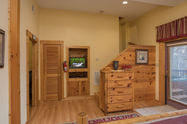 Dresser, closet, and TV in a bedroom with deck access at Precious View, a 1 bedroom cabin rental located in Gatlinburg