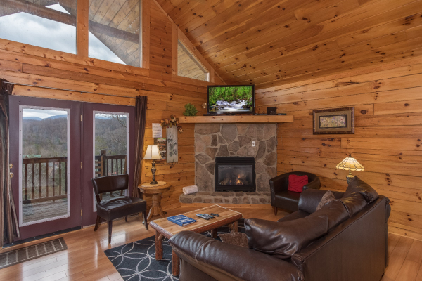 Living room with deck access, fireplace, and TV at Precious View, a 1 bedroom cabin rental located in Gatlinburg