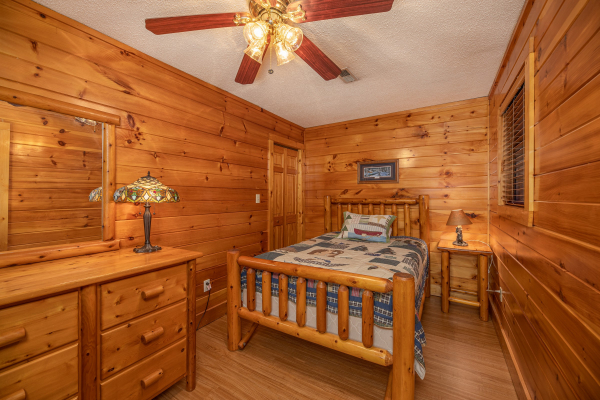 Bedroom with a bed, night stand, lamps, and dresser at Pine Splendor, a 5 bedroom cabin rental located in Pigeon Forge
