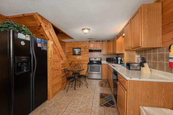 Kitchen with black and stainless appliances at Pine Splendor, a 5 bedroom cabin rental located in Pigeon Forge