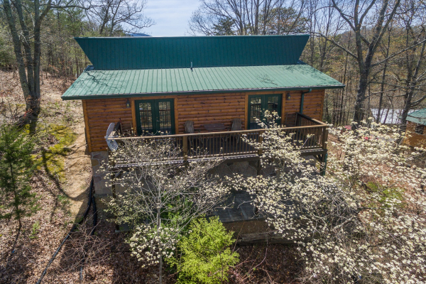 Looking back at the cabin through the budding trees at Pine Splendor, a 5 bedroom cabin rental located in Pigeon Forge