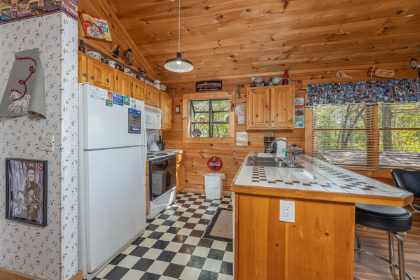 Kitchen with white appliances at Rock Around the Clock, a 1 bedroom cabin rental located in Pigeon Forge