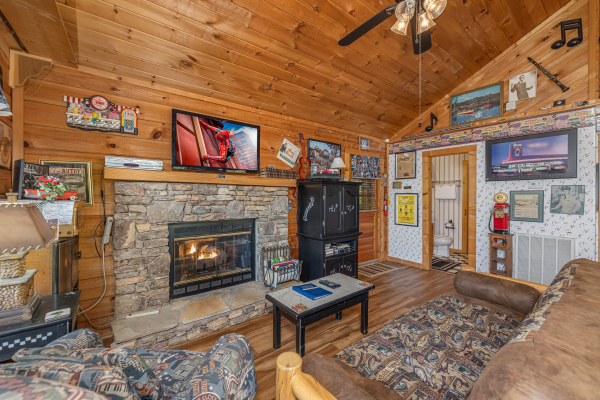 Fireplace and TV in a living room at Rock Around the Clock, a 1 bedroom cabin rental located in Pigeon Forge