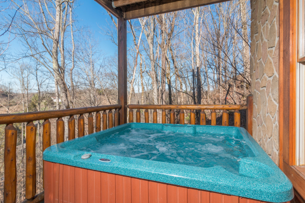 Hot tub on a covered deck at The Cowboy Way, a 4 bedroom cabin rental located in Pigeon Forge