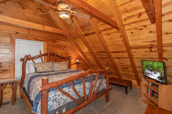 Bedroom with a log bed, book case, and TV at The Cowboy Way, a 4 bedroom cabin rental located in Pigeon Forge