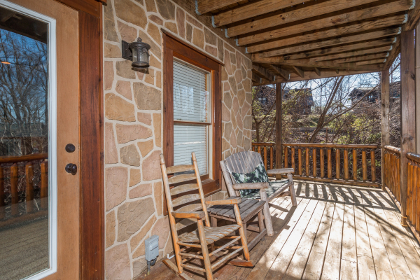 Deck with a rocking chair and bench at The Cowboy Way, a 4 bedroom cabin rental located in Pigeon Forge