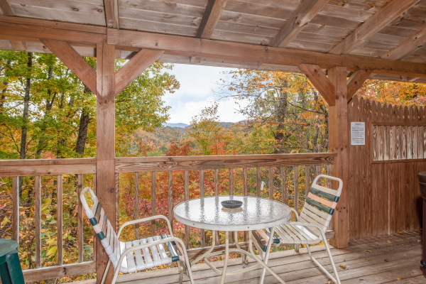 Covered deck with dining table for two at Love Me Tender, a 1 bedroom cabin rental located in Pigeon Forge