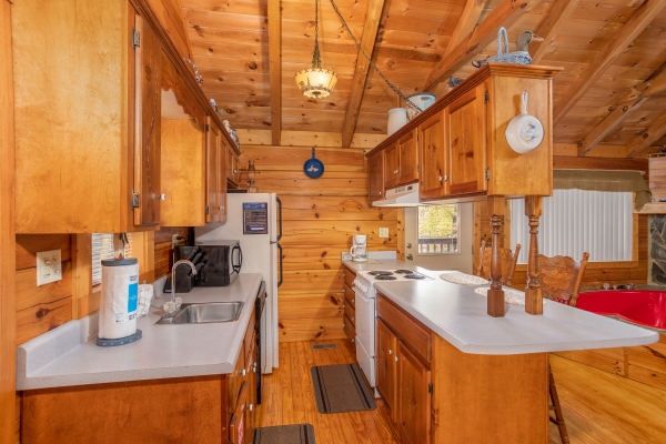 Galley style kitchen with white appliances Love Me Tender, a 1 bedroom cabin rental located in Pigeon Forge