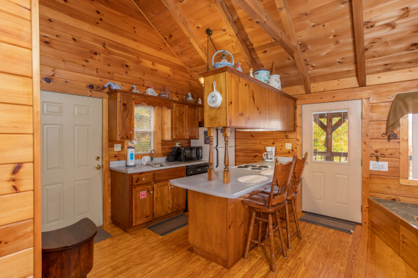 Kitchen and dining space for two at the breakfast bar at Love Me Tender, a 1 bedroom cabin rental located in Pigeon Forge