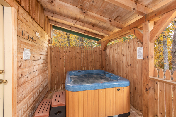 Hot tub on a covered porch with a privacy fence at All Shook Up, a 1 bedroom cabin rental located in Pigeon Forge