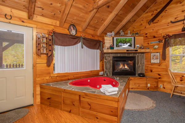 Jacuzzi and fireplace in a studio setting All Shook Up, a 1 bedroom cabin rental located in Pigeon Forge