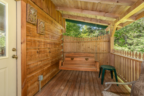 Swing on a covered deck at Forever Yours, a 1-bedroom cabin rental located in Pigeon Forge