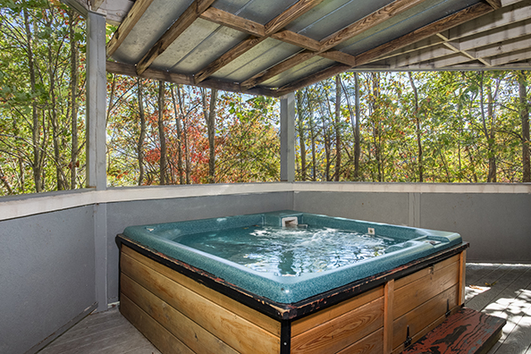 Hot tub on a covered deck at The Majestic, an 8 bedroom cabin rental located in Gatlinburg