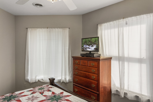Bedroom with a dresser and TV at Chalet Mignon, an 8-bedroom cabin rental located in Gatlinburg