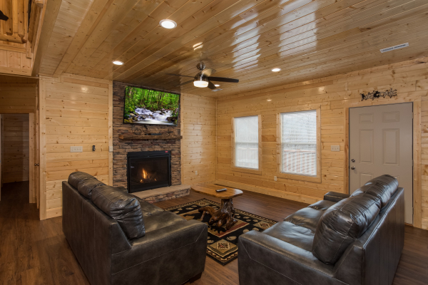 Fireplace and TV in a living room at Splash Mountain Lodge a 4 bedroom cabin rental located in Gatlinburg