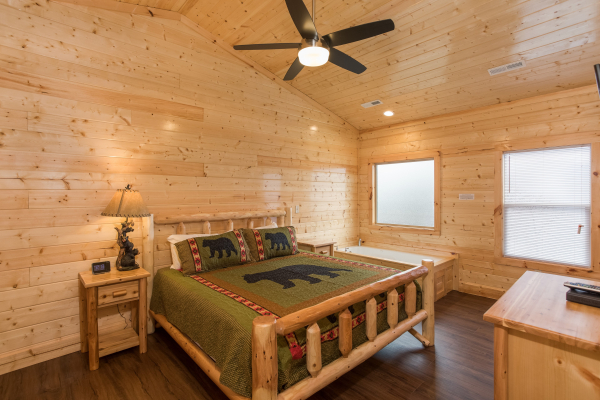 Bedroom with a king bed, night stand, and jacuzzi at Splash Mountain Lodge a 4 bedroom cabin rental located in Gatlinburg