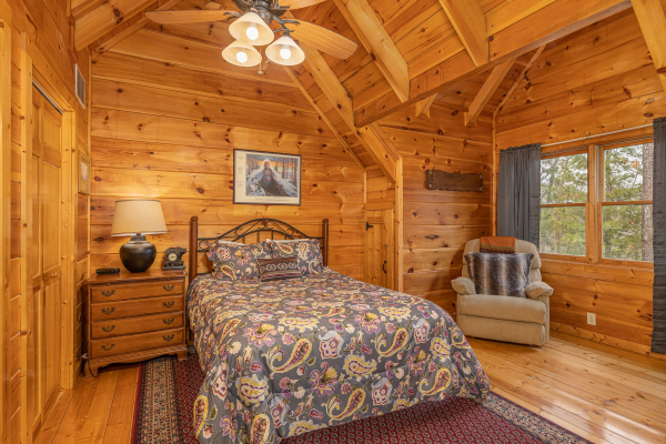 Bedroom with nightstand, lamp, and chair at Fox Ridge, a 3 bedroom cabin rental located in Pigeon Forge