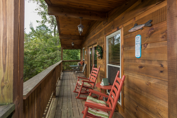 Rocking chairs on a covered deck at Bird's Eye View, a 2-bedroom cabin rental located in Gatlinburg