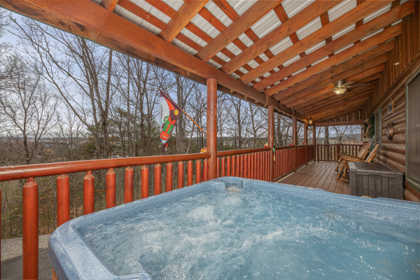 Hot tub on a covered deck with wooded views at Pigeon Forge Pleasures, a 3 bedroom cabin rental located in Pigeon Forge