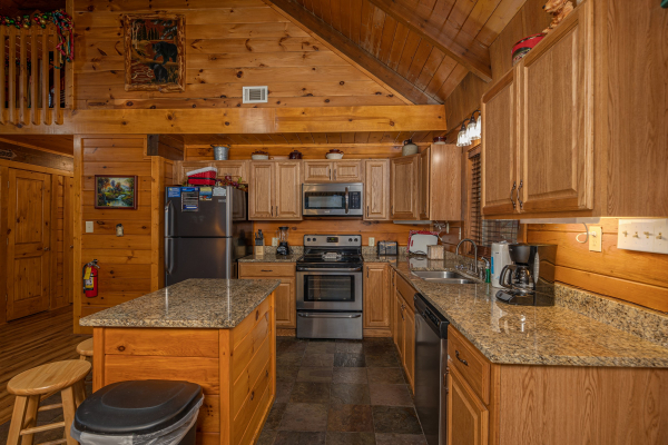 Kitchen with stainless appliances, granite counters, and island at Pigeon Forge Pleasures, a 3 bedroom cabin rental located in Pigeon Forge