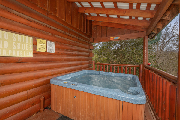 Hot tub on a covered deck at Pigeon Forge Pleasures, a 3 bedroom cabin rental located in Pigeon Forge