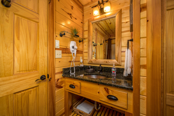 Bathroom sink and mirror at Gone To Therapy, a 2 bedroom cabin rental located in Gatlinburg
