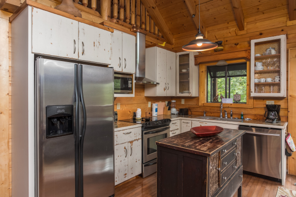 Kitchen with white cabinets and stainless appliances at Laid Back, a 2 bedroom cabin rental located in Pigeon Forge