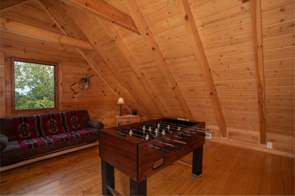 Foosball table and a futon in the loft at Cedar Creeks, a 2-bedroom cabin rental located near Douglas Lake