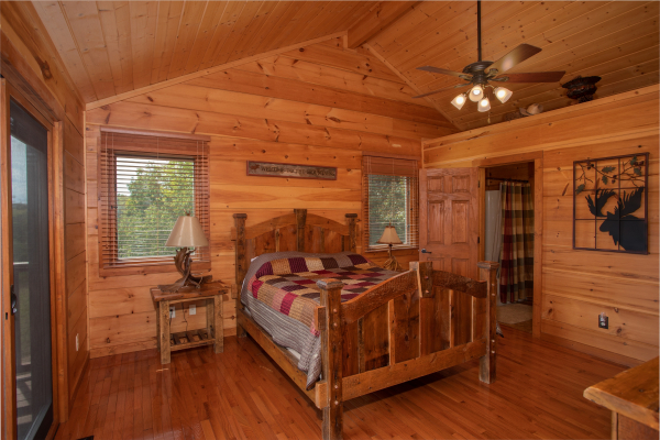 Queen-sized wooden bed in a bedroom with vaulted ceiling at Cedar Creeks, a 2-bedroom cabin rental located near Douglas Lake