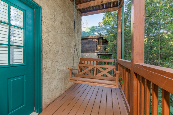 Swing on a covered porch at Southern Charm, a 2 bedroom cabin rental located in Pigeon Forge
