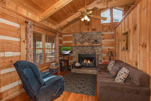 Fireplace, TV, recliner, and sofa in the living room at Blue Mountain Views, a 1 bedroom cabin rental located in  Pigeon Forge