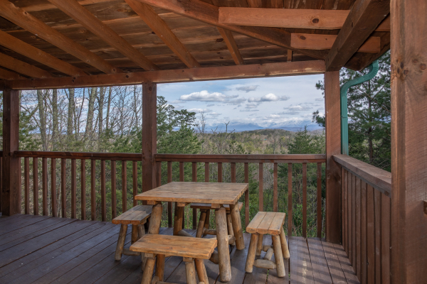 Outdoor dining space on the covered deck at Blue Mountain Views, a 1 bedroom cabin rental located in  Pigeon Forge