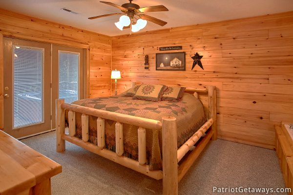King bed on the second floor with patio doors to deck at Alpine Sundance Trail, a 3 bedroom cabin rental located in Pigeon Forge