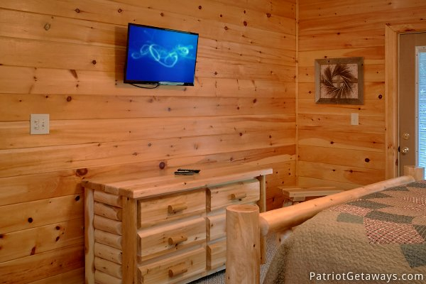 Wall mounted tv above drawers in a bedroom at Alpine Sundance Trail, a 3 bedroom cabin rental located in Pigeon Forge