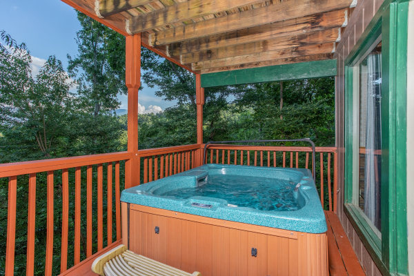 Hot tub on a covered deck at Bushwood Lodge, a 3-bedroom cabin rental located in Gatlinburg