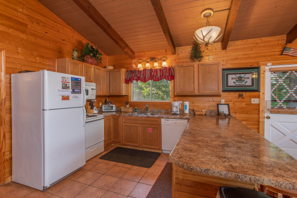 Kitchen with white appliances at Bushwood Lodge, a 3-bedroom cabin rental located in Gatlinburg