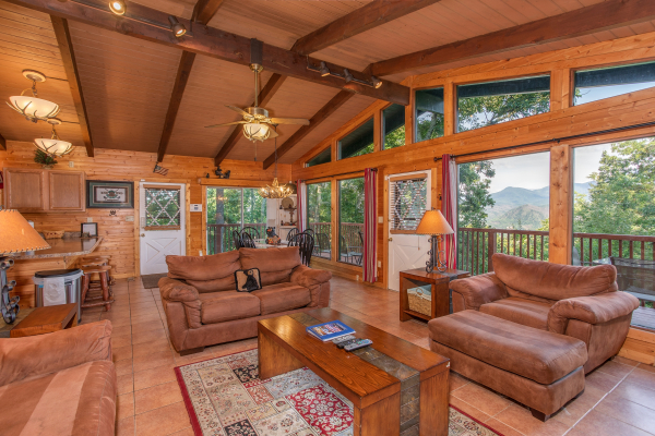 Vaulted living room with floor-to-ceiling windows at Bushwood Lodge, a 3-bedroom cabin rental located in Gatlinburg