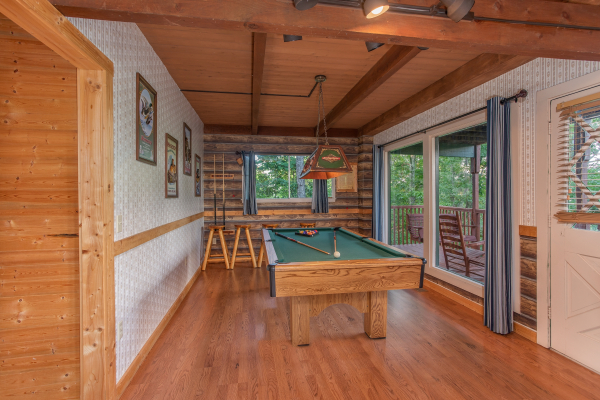 Green felted pool table in a game room at Bushwood Lodge, a 3-bedroom cabin rental located in Gatlinburg