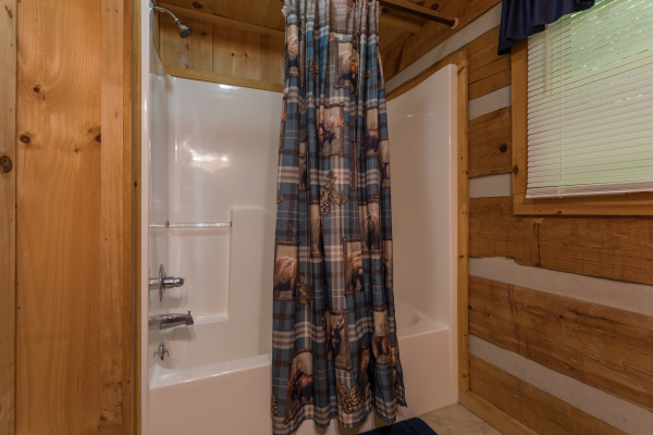Bathroom with a tub and shower at Bearfoot Crossing, a 1-bedroom cabin rental located in Pigeon Forge