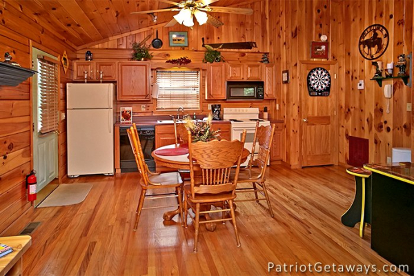 dining table with seating for four and the kitchen at always together forever a 1 bedroom cabin rental located in pigeon forge