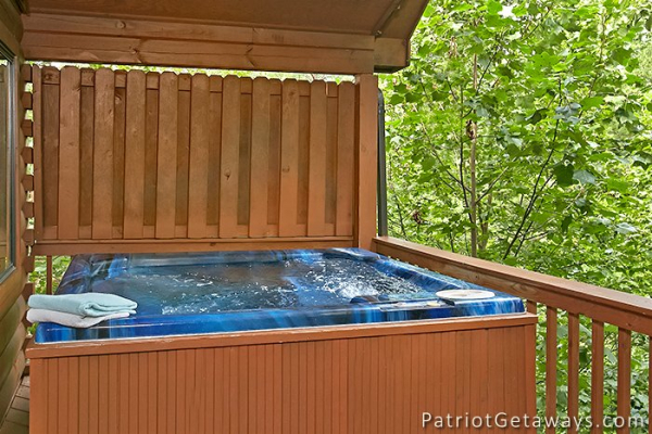 hot tub on a covered porch with privacy fence at always together forever a 1 bedroom cabin rental located in pigeon forge
