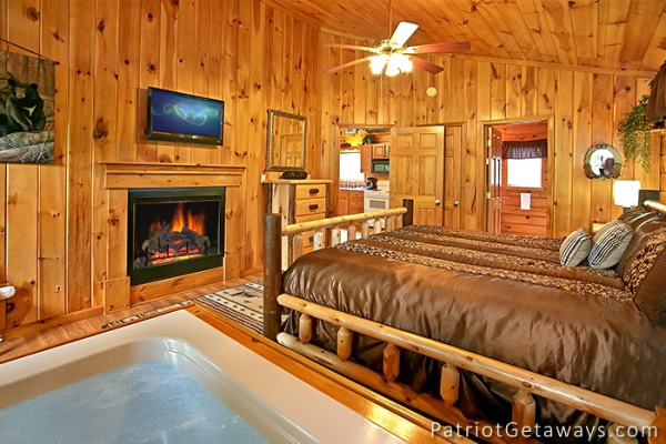 master bedroom with fireplace and jacuzzi at always together forever a 1 bedroom cabin rental located in pigeon forge