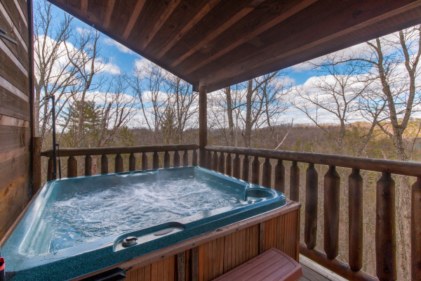 Hot tub on a covered deck at Moonshine Memories, a 2 bedroom cabin rental located in Gatlinburg