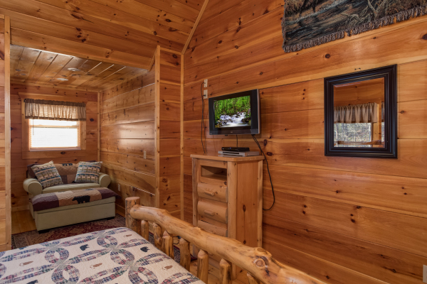 Loveseat, dresser, and TV in a bedroom at Moonshine Memories, a 2 bedroom cabin rental located in Gatlinburg