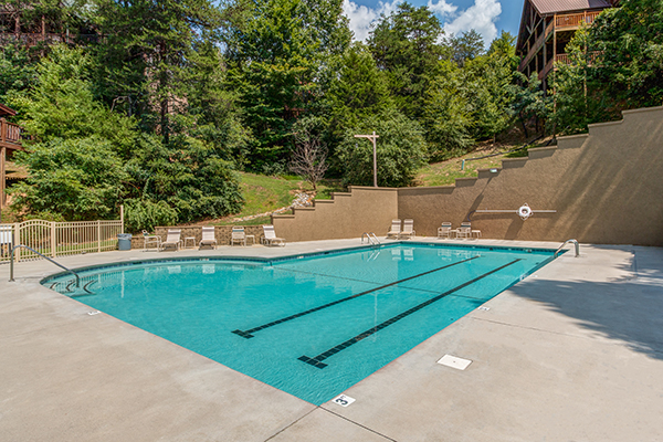 outdoor pool and lounge chairs in resort setting at alpine sunset thrill a 1 bedroom cabin rental located in pigeon forge