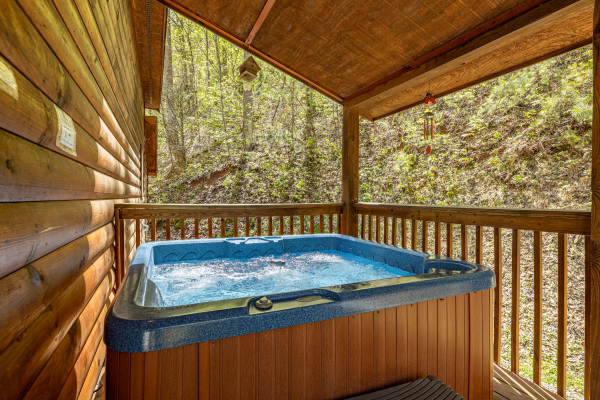 Hot tub on a covered porch at Hidden Joy, a 1 bedroom cabin rental located in Gatlinburg