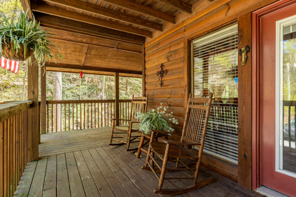 Rocking chairs on a covered deck at Hidden Joy, a 1 bedroom cabin rental located in Gatlinburg